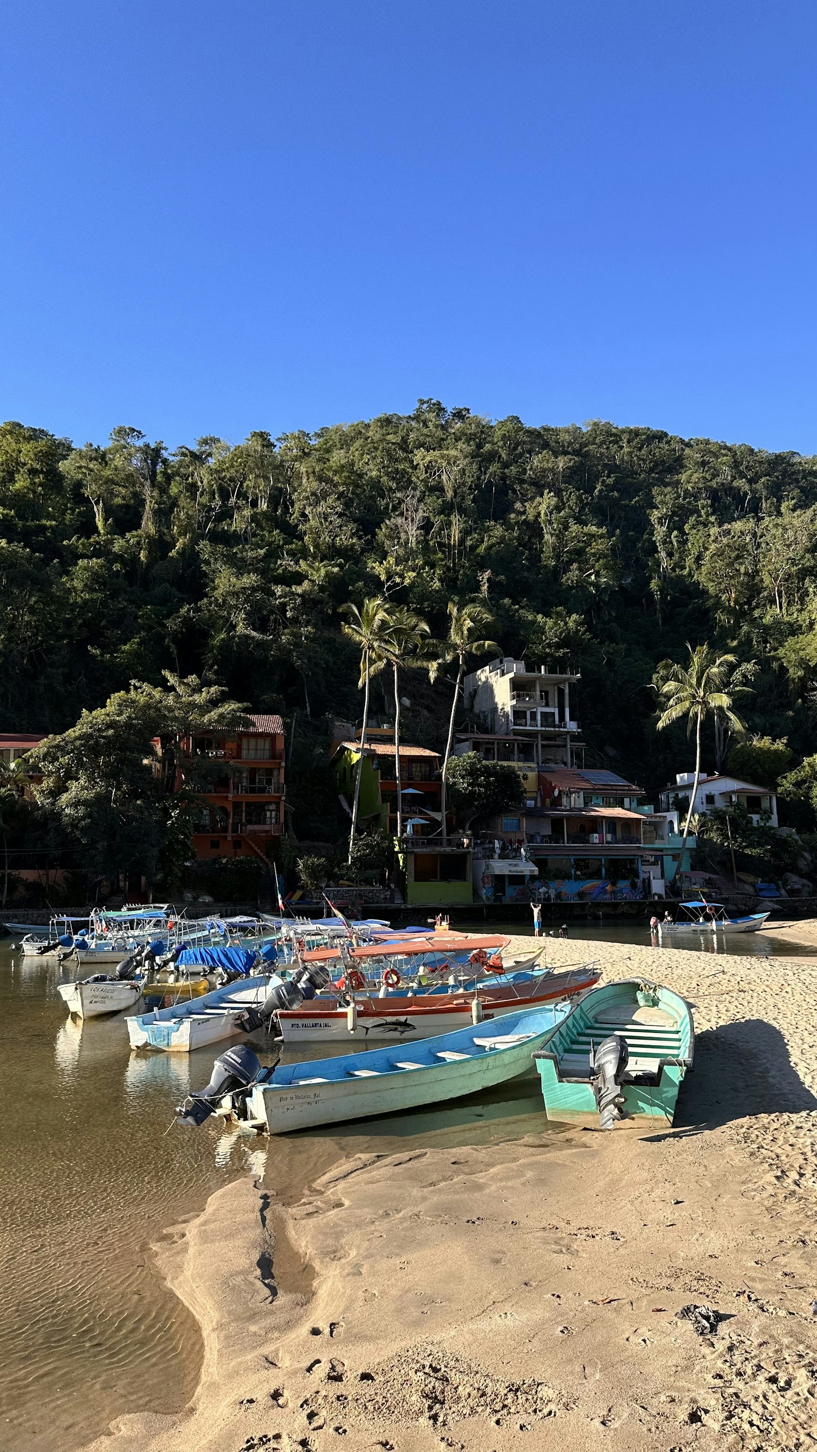 A group of boats sitting on top of a sandy beach